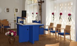 Blauer Altar in einer Kapelle und Stühlen und Kruzifix | © Susanne Wagner